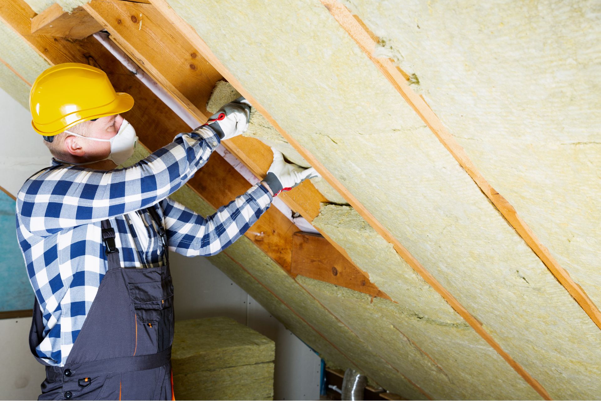 A professional is insulating a metal roof with batt.