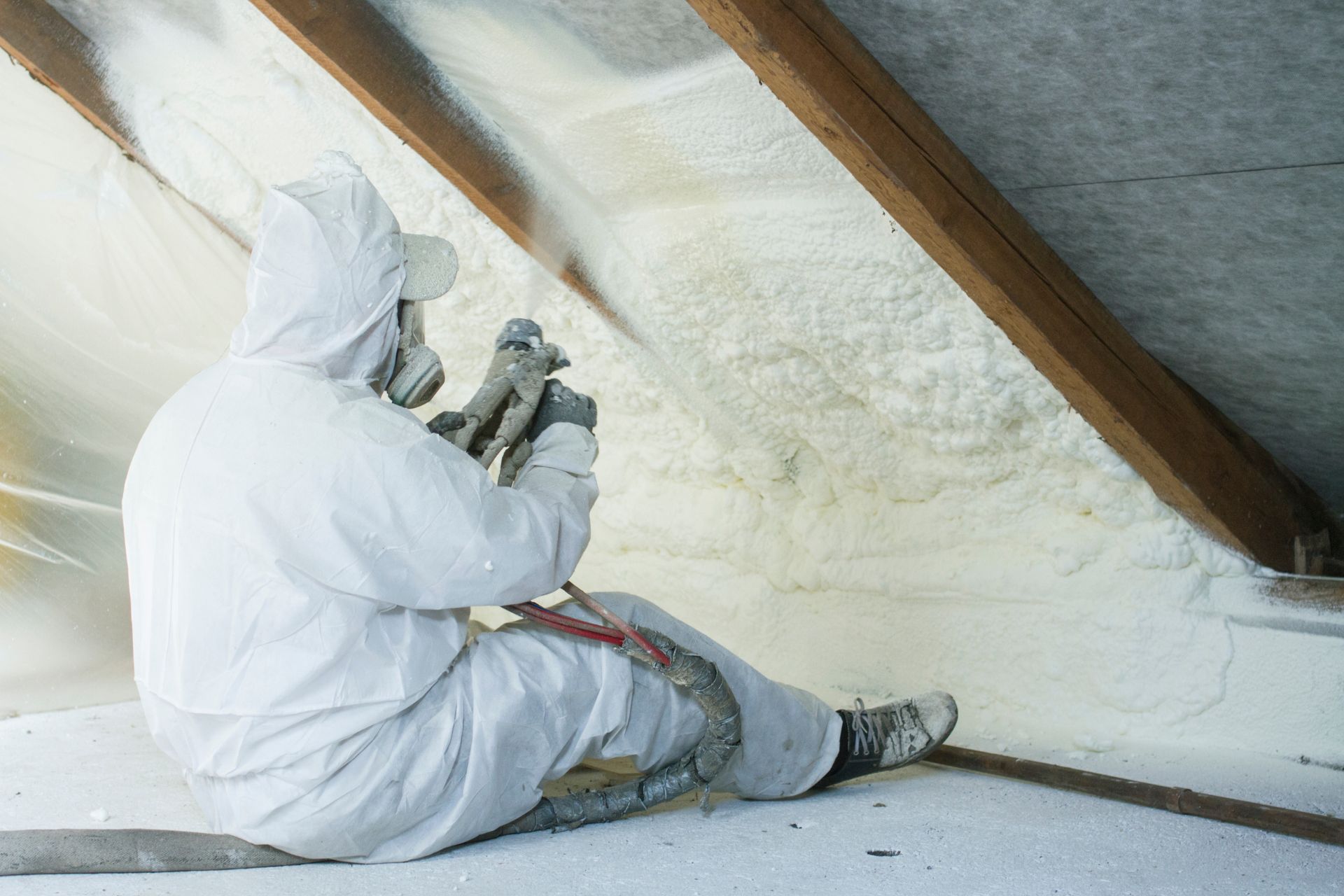 A professional in insulating a metal roof from the inside with spray foam.